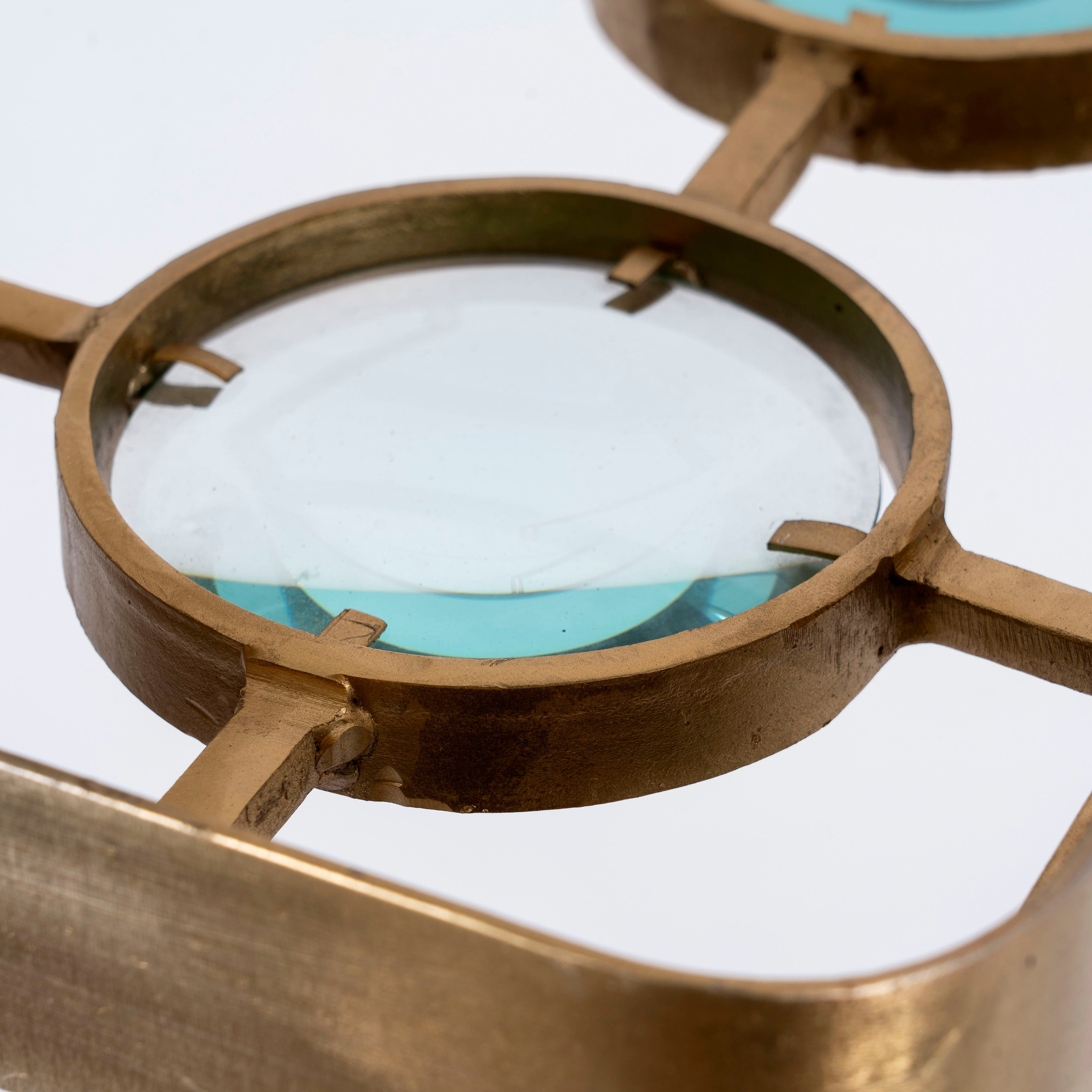 Close up image of a unique pendant light with brass-plated iron square frame and magnifying blue and white glass inserts – vintage lighting piece ideal for kitchens, living rooms, or entryways.