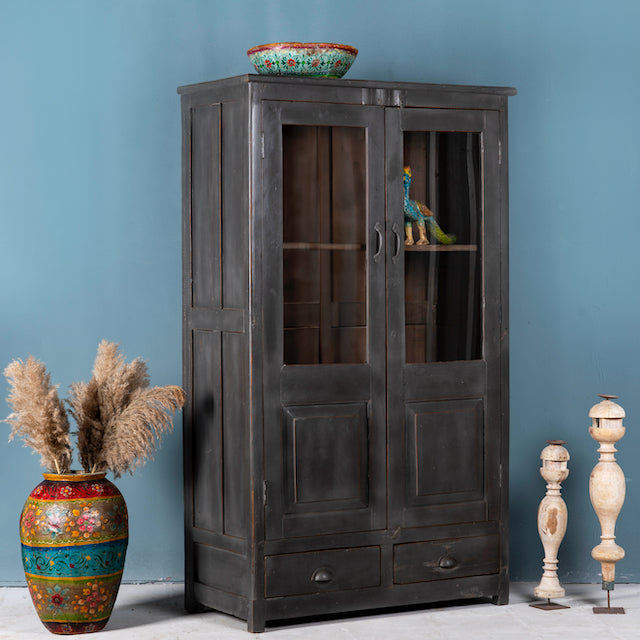Side angle image of a refurbished teak wood cabinet with shabby chic grey finish and glass-panelled doors – sustainable furniture for elegant living and dining spaces.