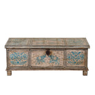 White background image of a large hand-painted chest made from old reclaimed wood, featuring intricate blue designs of elephants and floral motifs on a distressed beige background, with a central latch and a rustic vintage finish.
