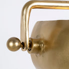 Close up image of a round artsy pendant lamp with clear hand-blown glass and brass-plated iron frame – retro lighting piece ideal for kitchens, dining rooms, or living areas.