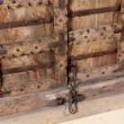 Close-up of an old wooden door with metal hinges and locks