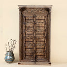 Unique wardrobe made from a reclaimed old teak wood door, featuring original iron fittings and hand-carved floral details in a rustic vintage finish.