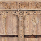 Close up image of a rustic solid wood wardrobe featuring vintage reclaimed door panels with iron accents and ring pull handles.