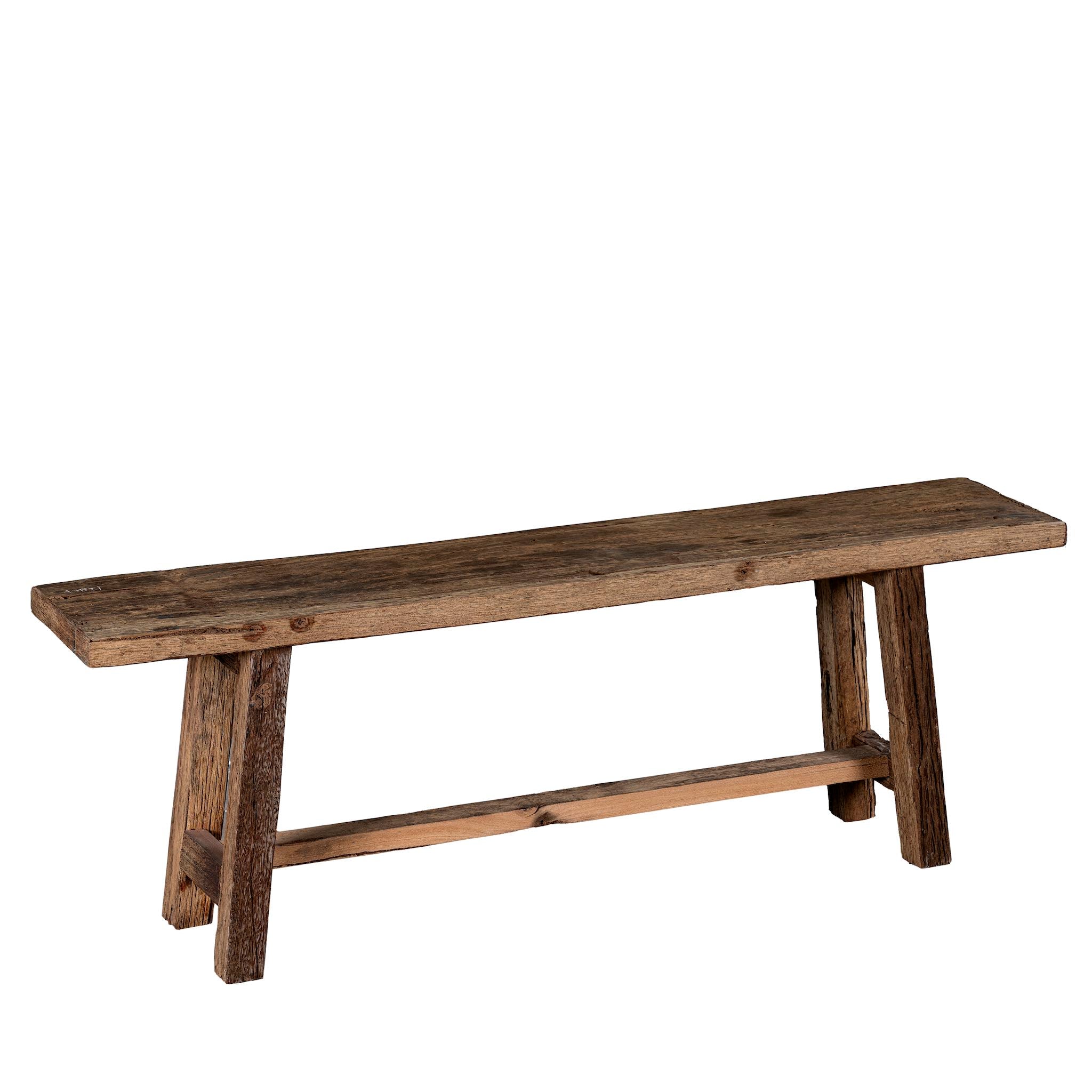 White background image of a rustic wooden bench made from reclaimed wood, featuring a long, narrow seat with a weathered finish and sturdy angled legs connected by a simple support beam.
