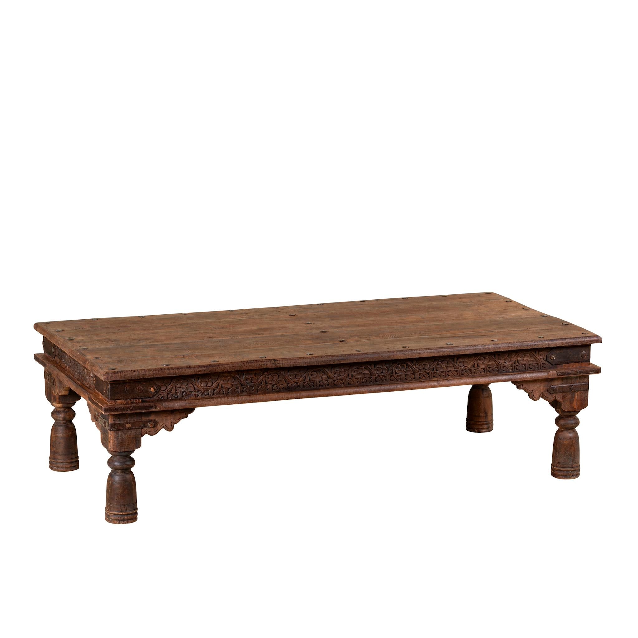 Wooden table with intricate carvings on a white background