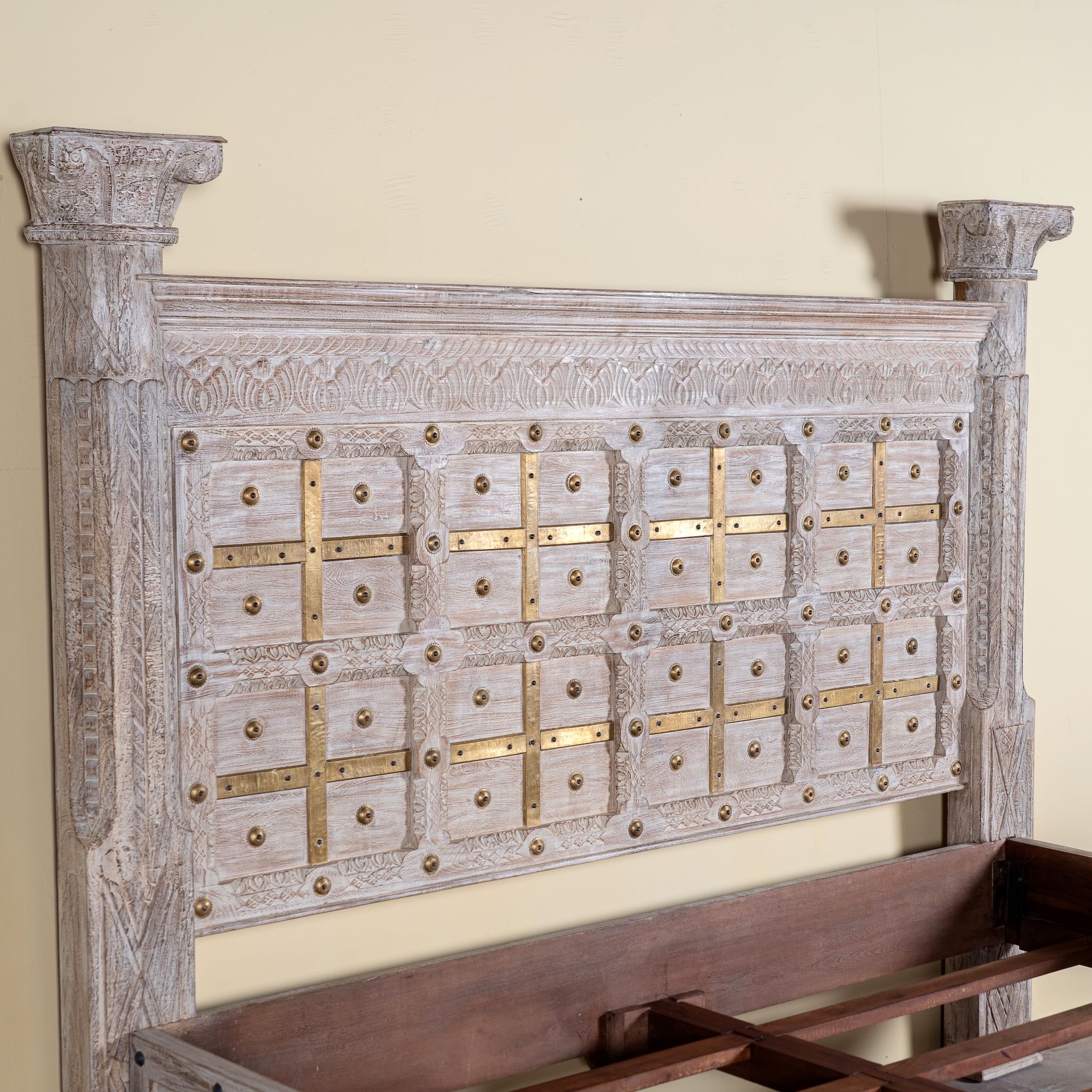 Close up image of a handcrafted four poster bed made from reclaimed wood with carved detailing – Mirai model by Om Home & Garden