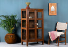 Side angle image of a compact reclaimed teak wood display cabinet with two glass doors and shelving – sustainable teak wood furniture combining functional design and unique character.