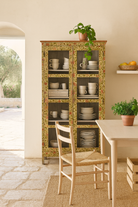 Lifestyle image of a hand-painted reclaimed wood cabinet with glass doors and floral motifs – sustainable and artistic furniture for vintage or bohemian interiors.