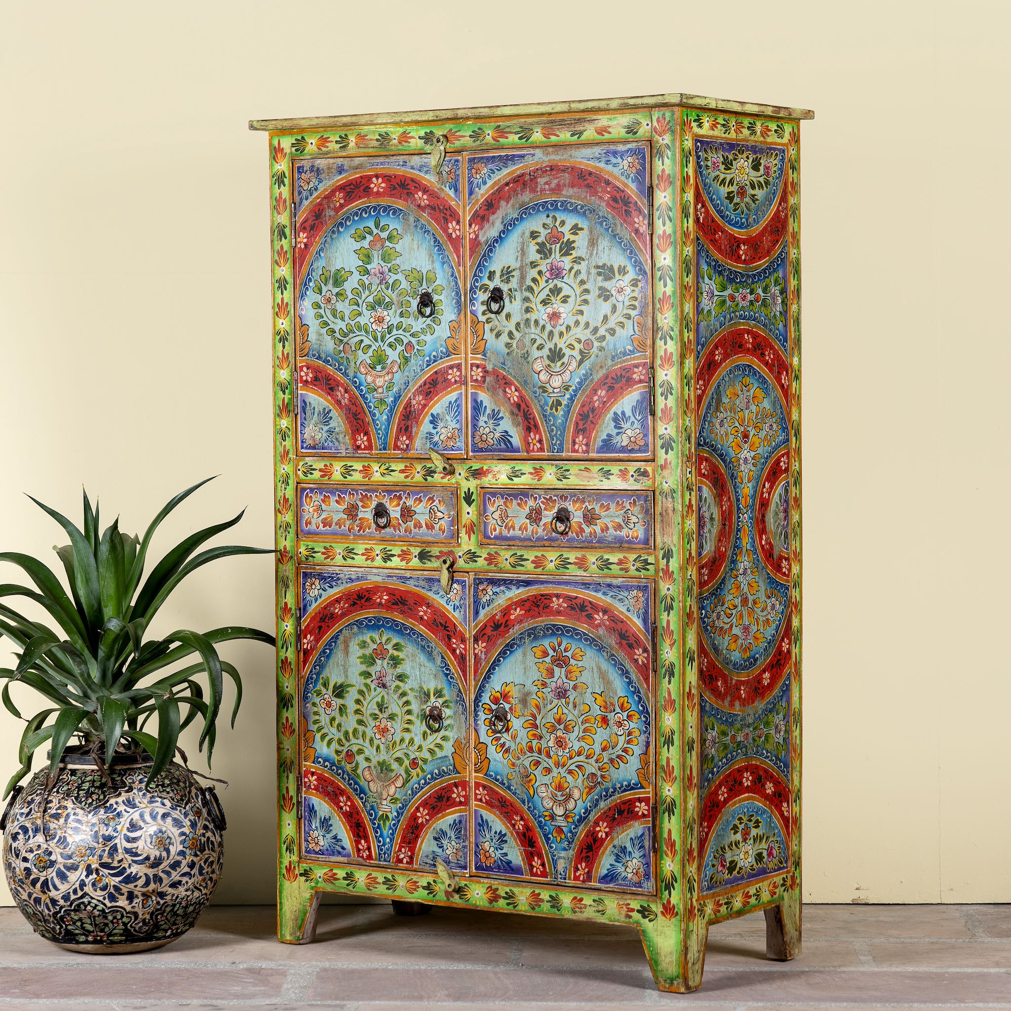 Side angle image of a hand-painted cabinet made from reclaimed wood with colourful floral motifs – a sustainable furniture piece ideal for expressive Indian home decor.