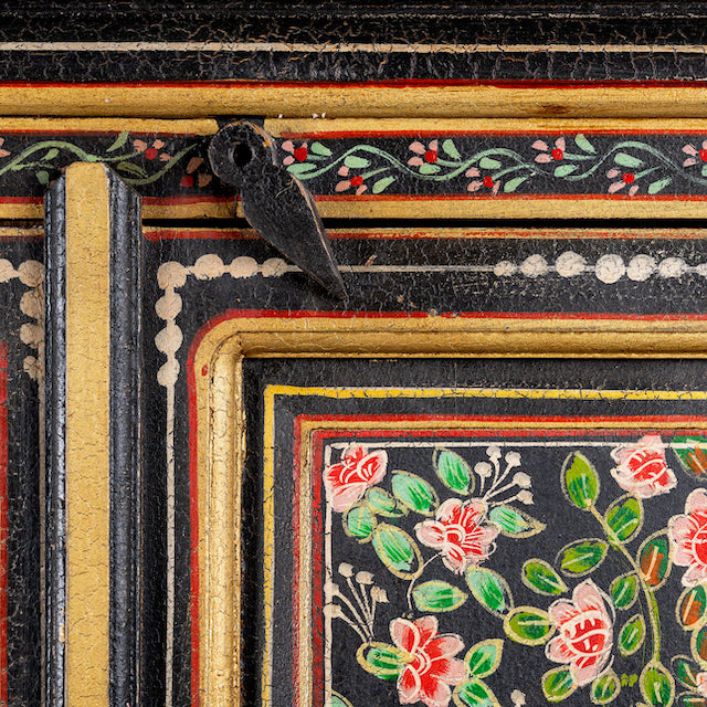 Close up image of a hand-painted cabinet made from recycled wood with floral motifs – sustainable furniture and unique furniture for bold, artistic interiors.
