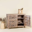 Open doors image of a hand-carved  sideboard in mango wood furniture style with two doors, three drawers, and vintage three-layer finish.