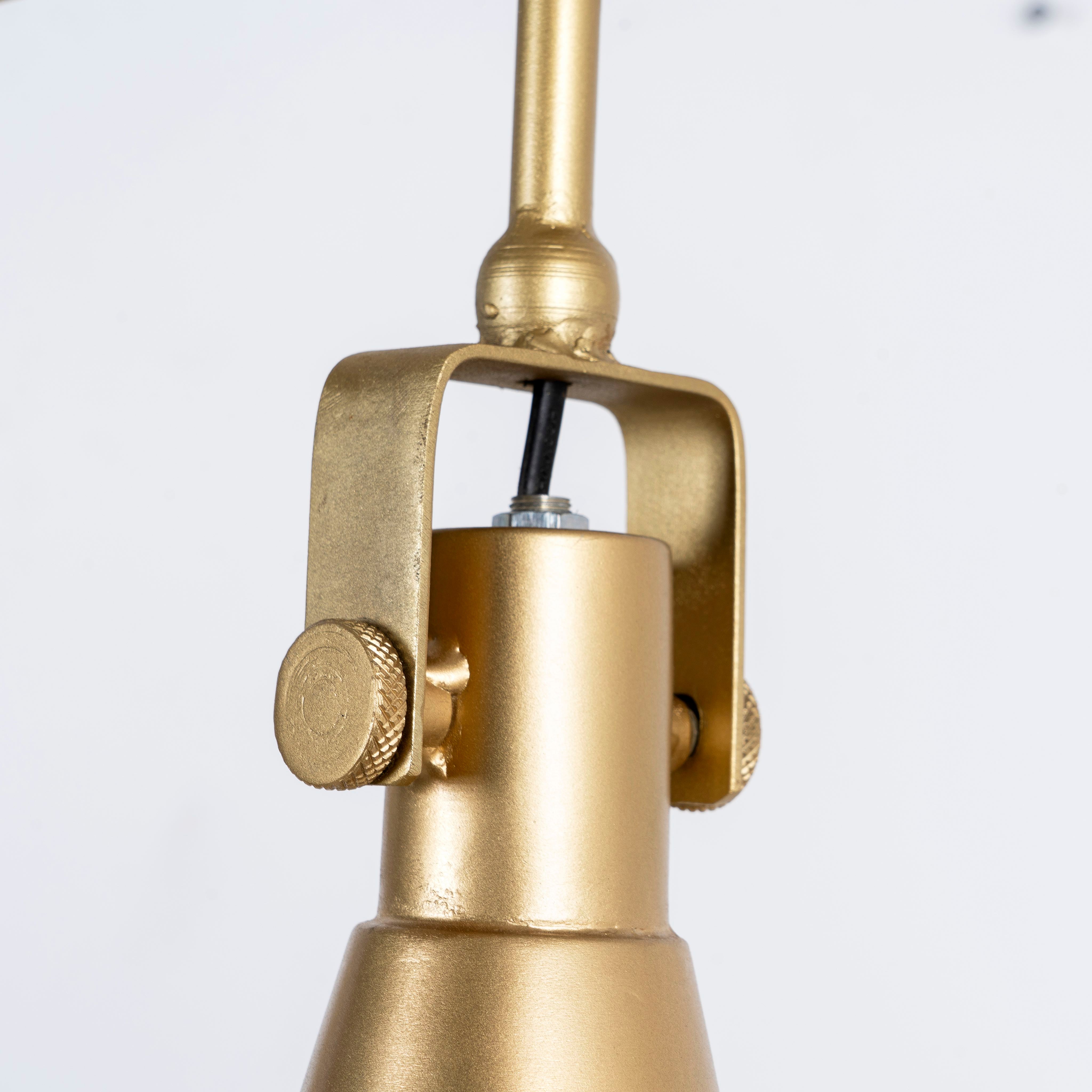Close up image of a three-light iron pendant lamp with brass finish and tapered design – minimalistic style lighting and iron pendant lights for modern interiors.