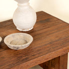 Close up picture of a minimalist coffee table made from reclaimed wood, featuring a solid rectangular top and block legs for a clean, contemporary look with rustic warmth.

