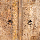 Close up image of a hand-carved mango wood cabinet with traditional Indian village scenes – Rewalsar by Om Home & Garden, carved wooden furniture with cultural depth for bedroom interiors.