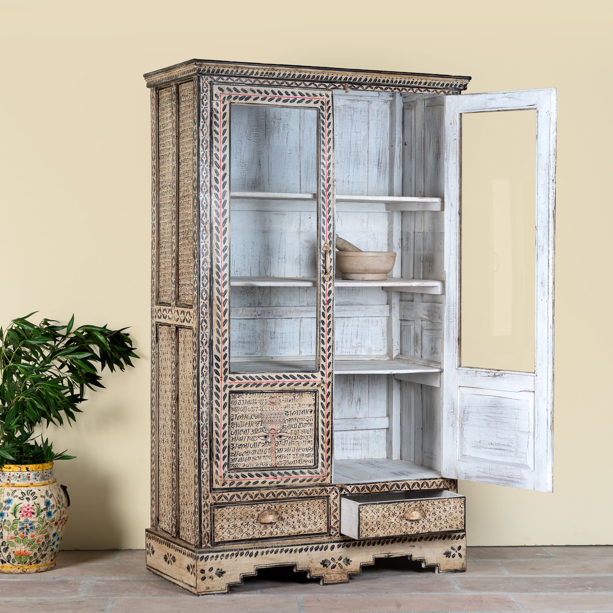 Side angle image with open doors of a of a hand-painted display cabinet Sambalpur made from recycled wood with glass doors – sustainable furniture featuring Sanskrit motifs and traditional Indian craftsmanship.