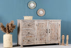 Side angle image of a and‑carved vintage style mango wood sideboard with distressed floral lattice panels, 150 × 40 × 90 cm.