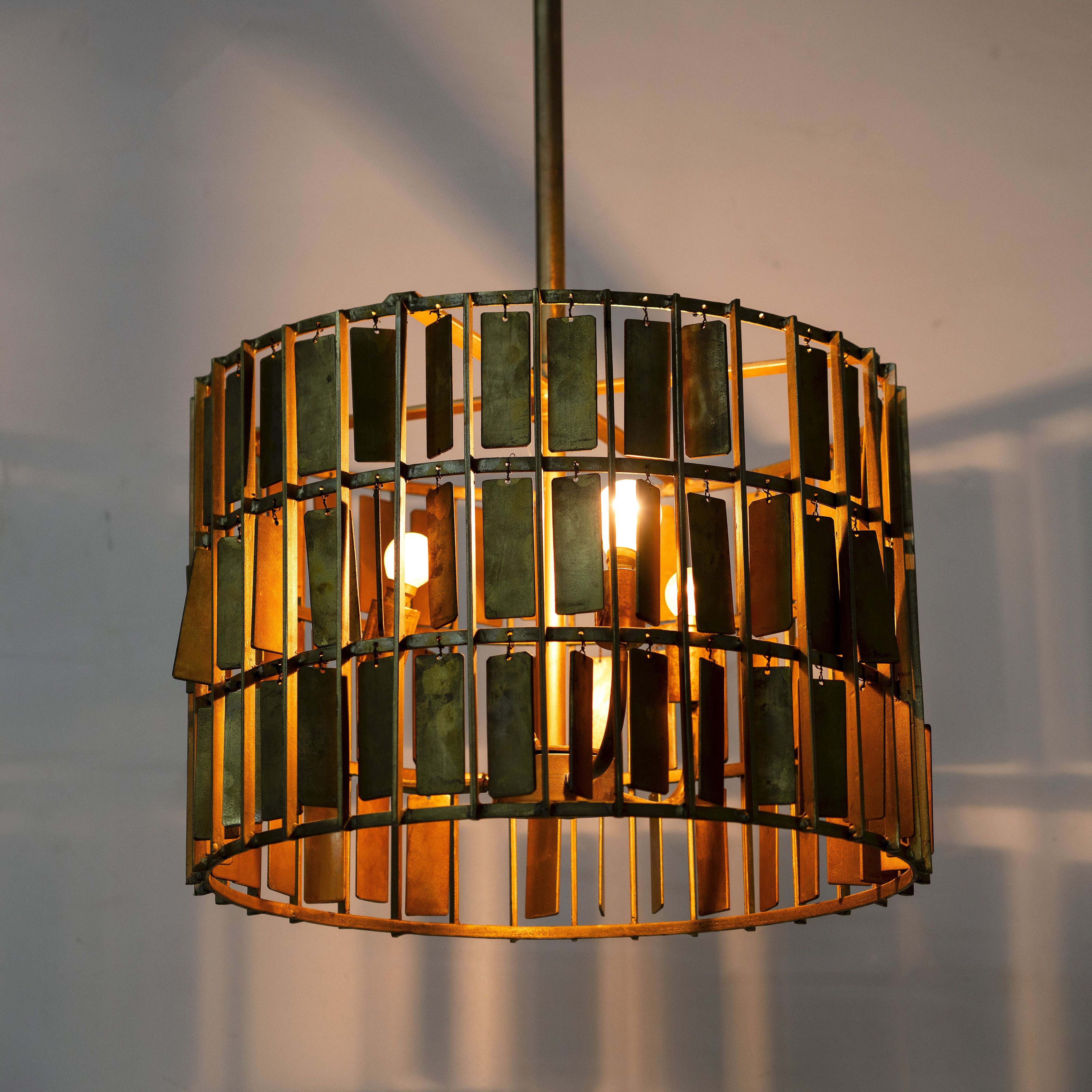 Lighted version of a Large round brass-plated iron pendant lamp with ornate tile surface – vintage lighting and iron pendant light ideal for dining rooms or living spaces.