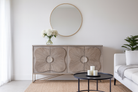 Lifestyle imagination of a handcrafted mango wood sideboard with floral-inspired sunburst carving, grey wash finish, and silver accents – mid century style furniture for elegant living spaces.