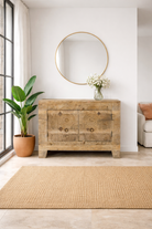 Lifestyle imagination of a sideboard Taksh made from reclaimed teak wood, featuring carved antique Indian door fronts with circular mandala motifs. A unique piece of old door furniture combining Mediterranean style with traditional Indian craftsmanship.