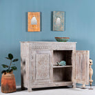 Side angle image with open doors of a grey-washed reclaimed wood cabinet with hand-carved floral and sunburst detailing, a vintage furniture piece perfect for rustic or bohemian interiors.