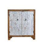 White background image of a hand-carved mango wood cupboard Utkarsh with whitewashed doors featuring palm tree and botanical motifs. A Mediterranean-inspired piece of Indian furniture combining artisan detail with practical storage.