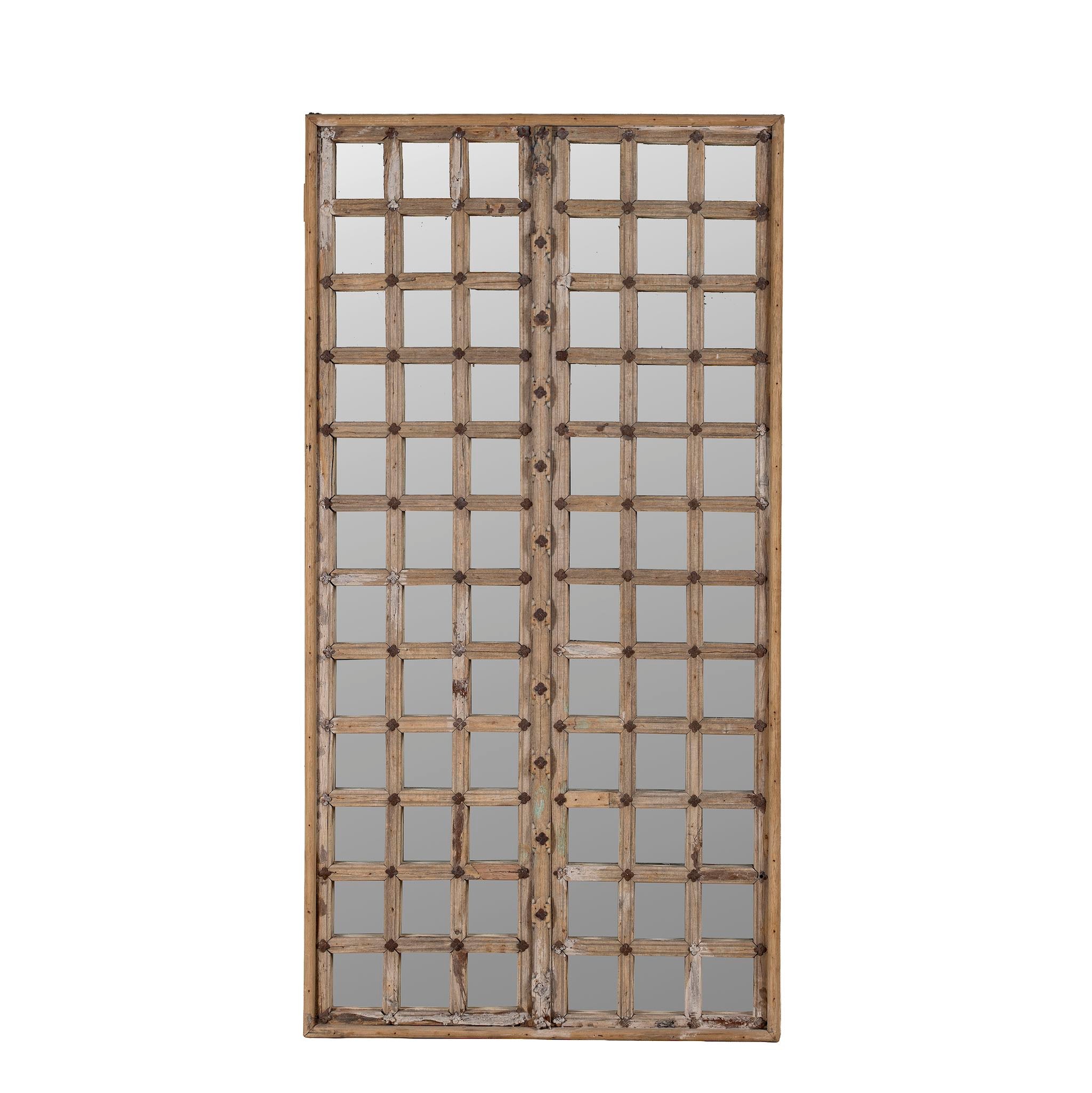 White background picture of a wooden door mirror with antique teak frame and carvings, part of our Indian home decor collection.