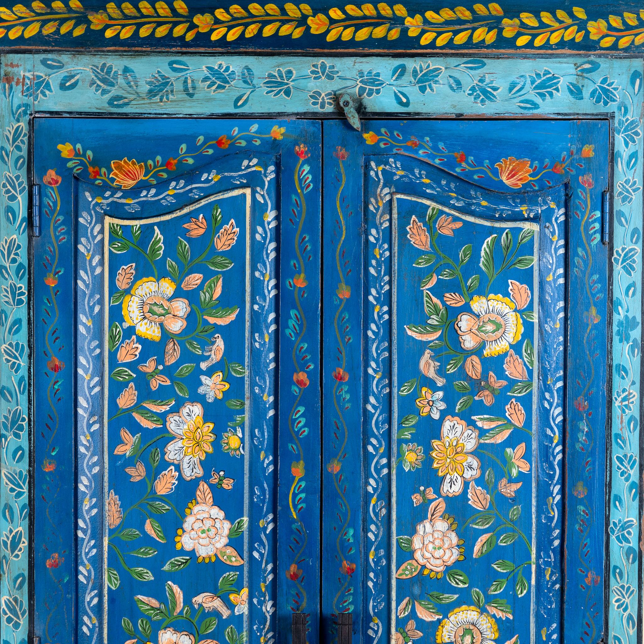 Close up image of a hand-painted wardrobe made of reclaimed wood in vibrant blue floral design – Yuvika model by Om Home & Garden