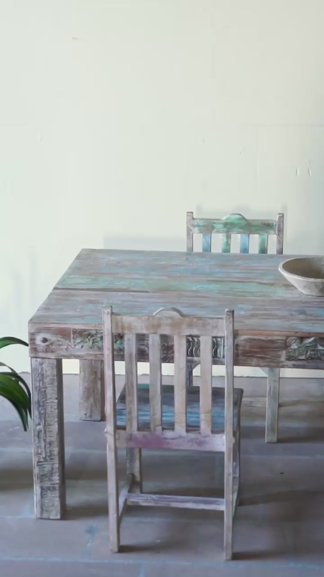 Reel showing of a reclaimed wood dining set Ayla with one vintage table and six rustic chairs. A handcrafted bohemian interior piece combining sustainable materials with artistic, timeworn charm.