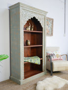 Side angle image of a hand-carved mango wood bookcase with Mediterranean design and open shelving – mango wood shelving and hand carved wooden furniture with natural finish.