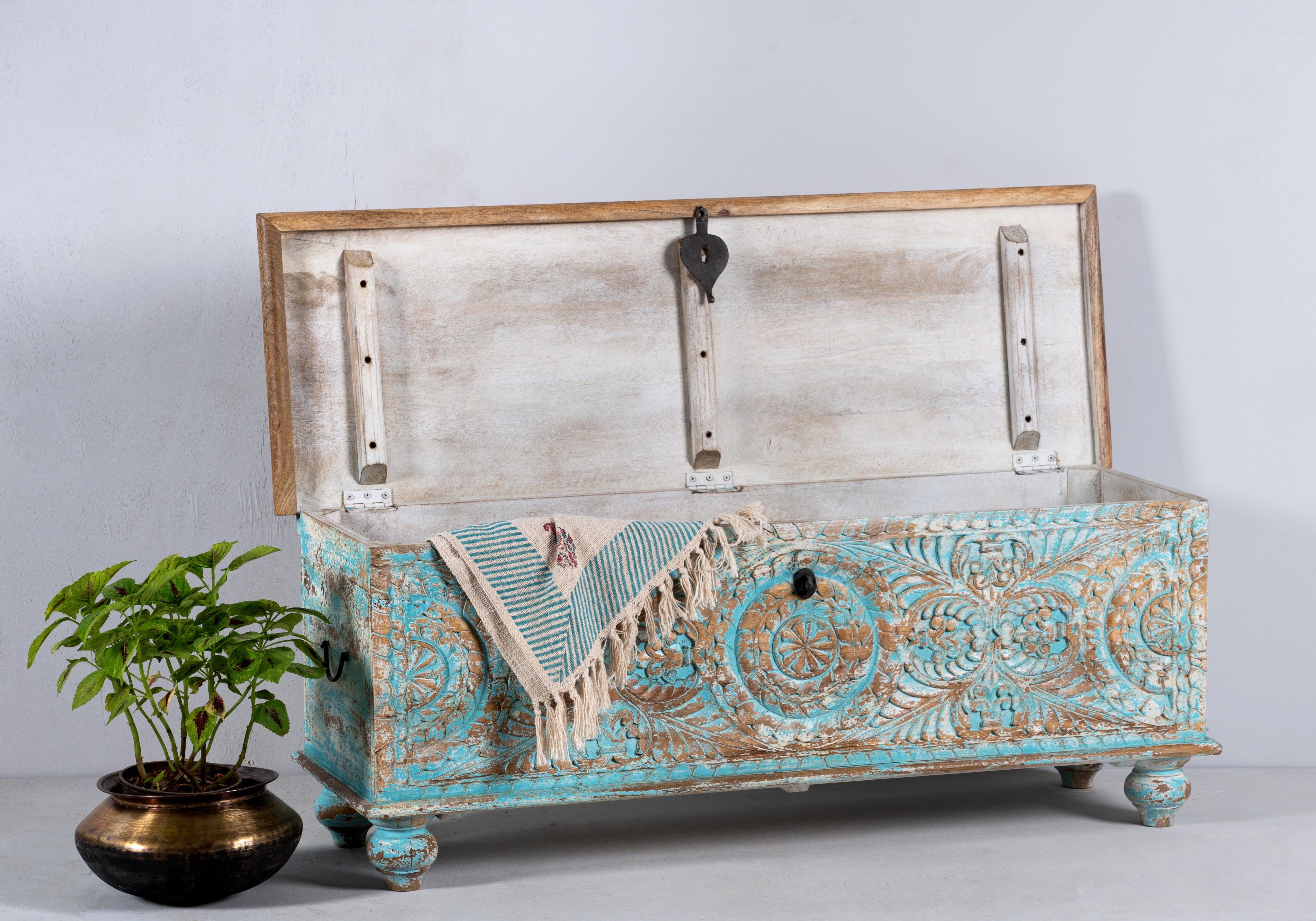 Side angle image of a hand-carved mango wood chest in blue with natural wood top – carved wooden furniture and wooden storage chest for eclectic or boho interiors.