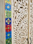Close up image of a hand-carved mango wood cabinet with white-wash finish and ceramic detailing – artisanal furniture and carved wooden furniture with Mediterranean flair.